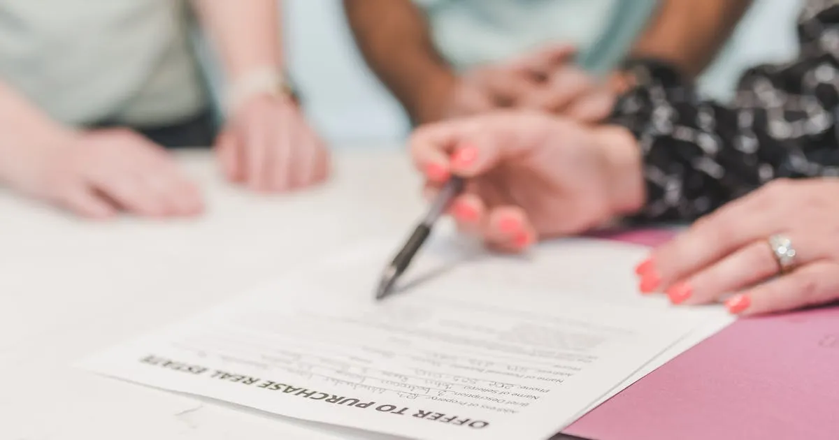 Couple primo-accédant signant un contrat de réservation VEFA avec un promoteur immobilier neuf