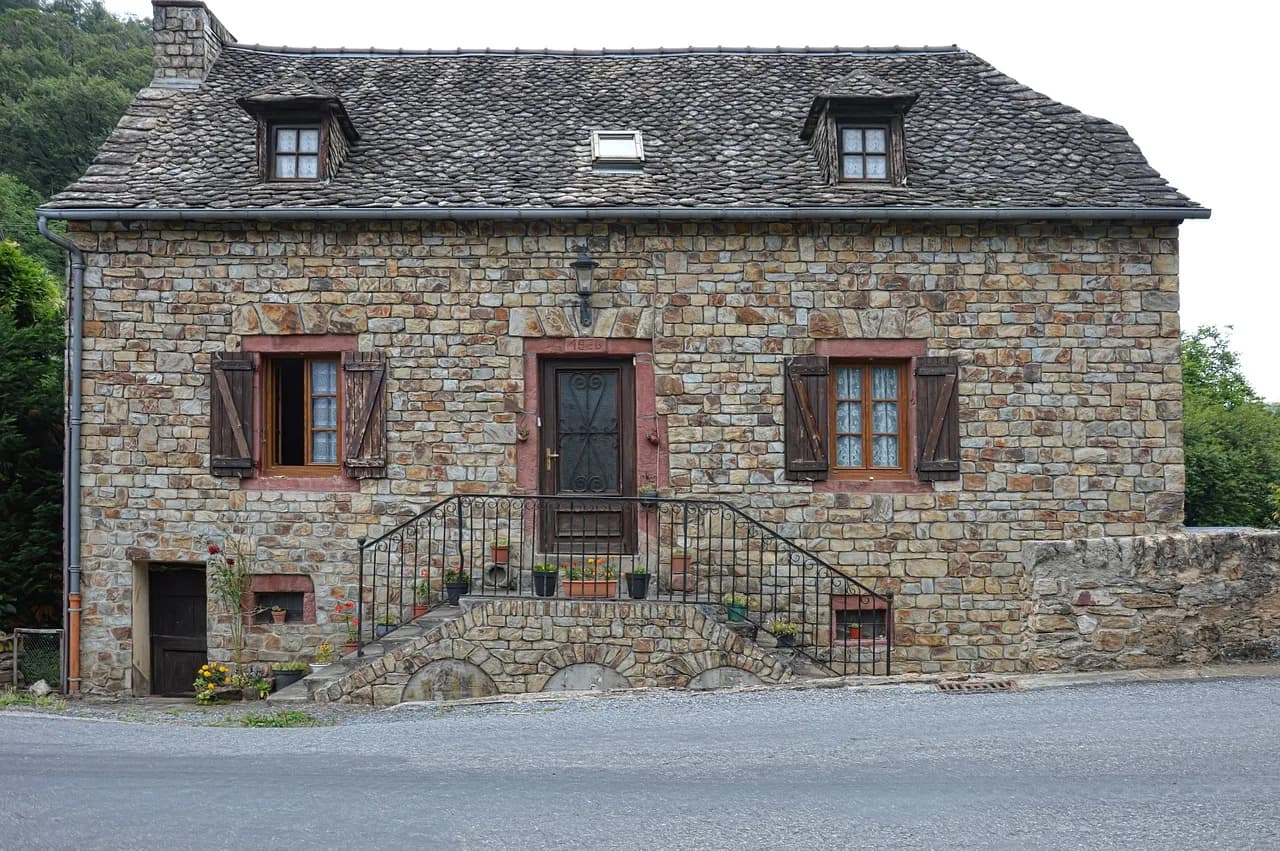 Maison ancienne en pierre dans un village rural d'Aveyron, typique des biens éligibles au PTZ ancien avec travaux en zones B2 et C