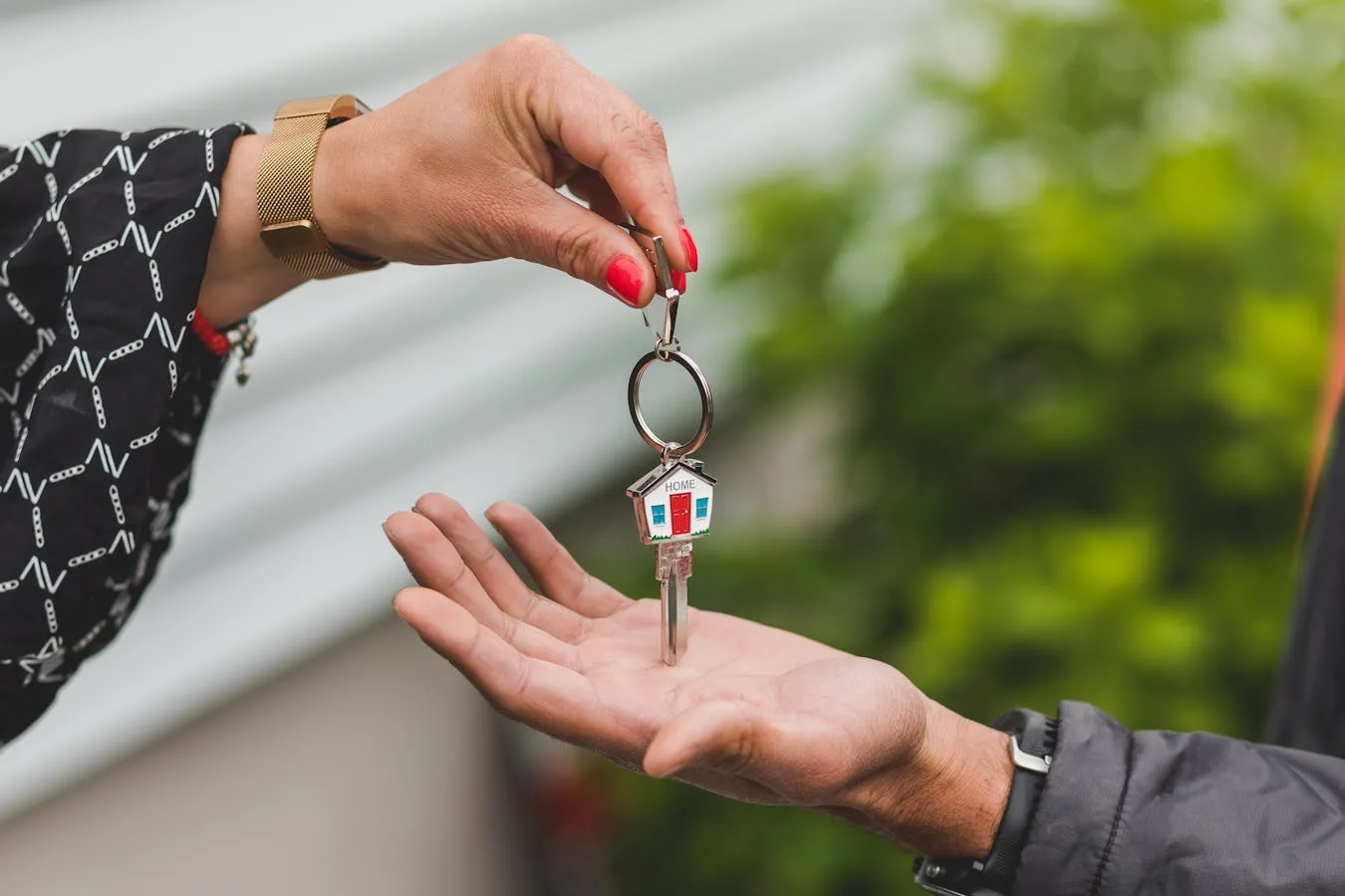 Mains tenant des clés de maison sur fond neutre — PTZ après décès du conjoint 2026
