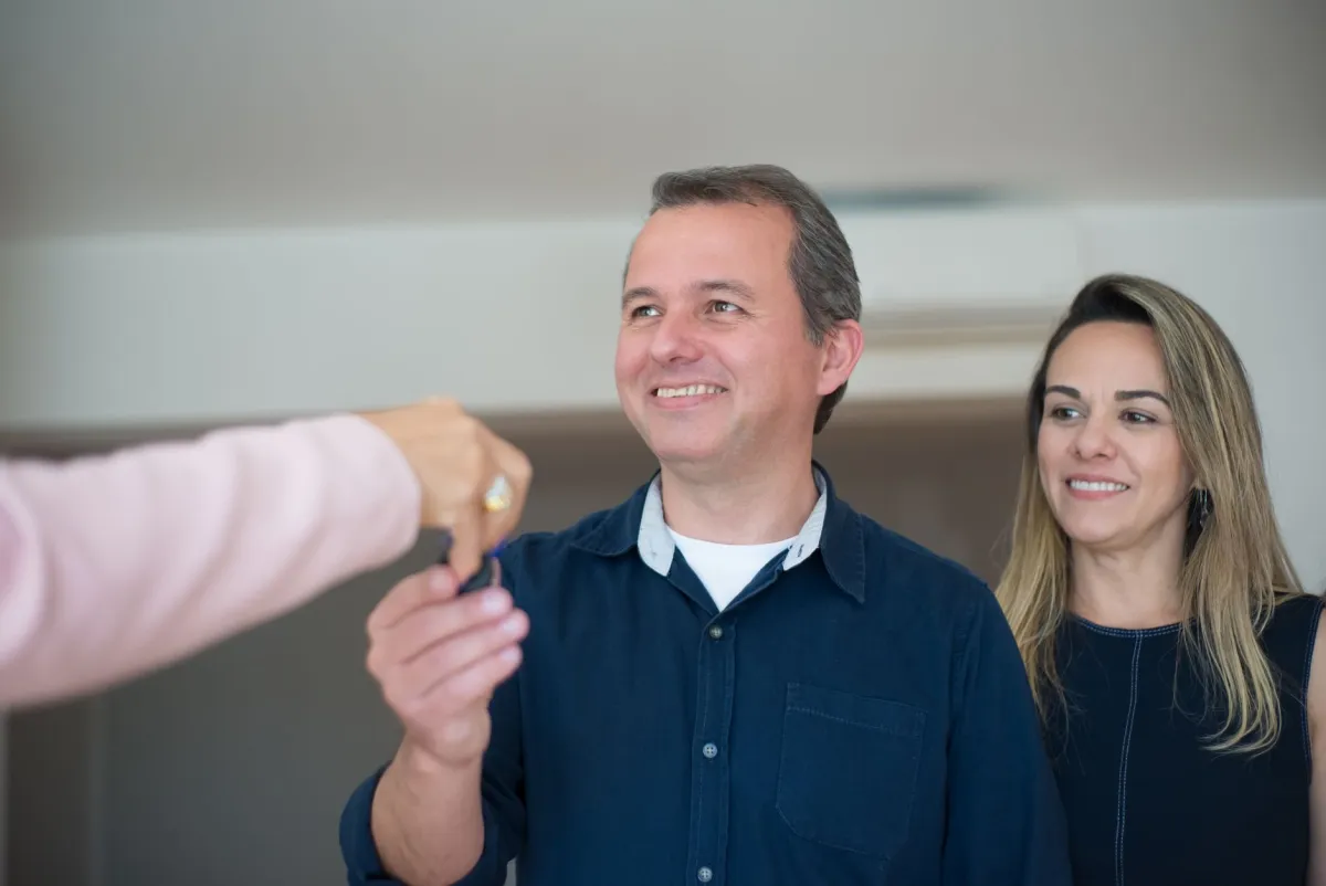 Couple récupérant les clés de son nouveau logement acheté grâce à un prêt relais